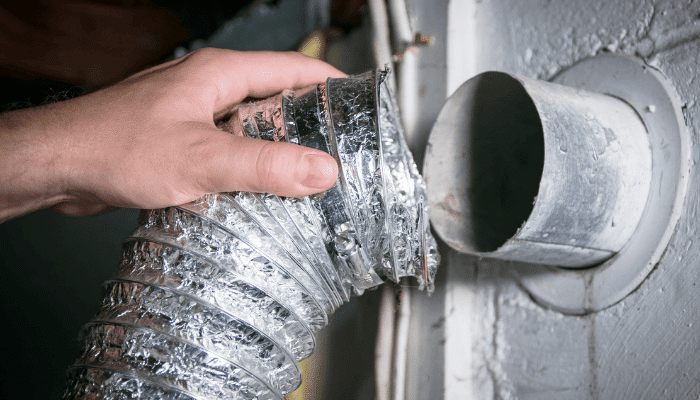 Technician connecting an air duct vent for HVAC system cleaning.