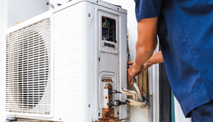HVAC technician performing routine maintenance on an outdoor air conditioning unit in St. Petersburg FL